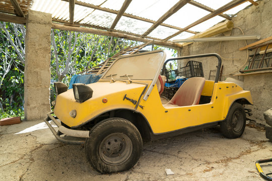Yellow beach buggy in some other carport