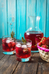 Cocktail-mocktail. Fruity cocktail drink decorated with frozen or fresh raspberry, strawberry, rosemary, ice and soda. Domestic cocktail with ice and rosemary