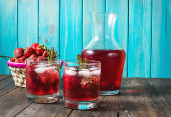 Cocktail-mocktail. Fruity cocktail drink decorated with frozen or fresh raspberry, strawberry, rosemary, ice and soda. Domestic cocktail with ice and rosemary