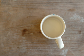 Fototapeta na wymiar cup of milk on wooden floor, top view