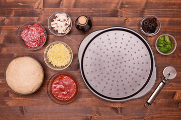 Pizza ingredients ready to be laid on the baking plate