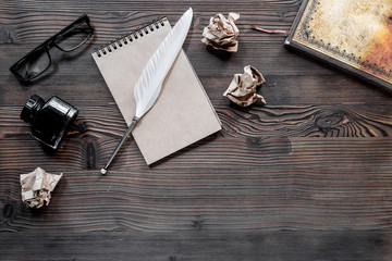 Writer concept. Feather pen, vintage notebook and crumpled paper on wooden table background top view copyspace