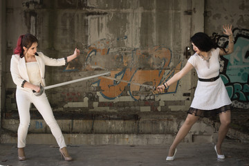 Obraz na płótnie Canvas Two businesswomen are fighting at swords.