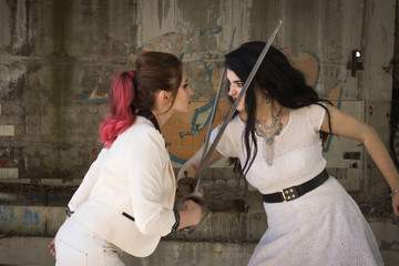 Two businesswomen are fighting at swords.