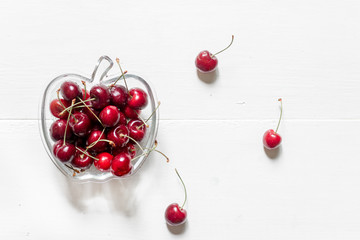 Naklejka na ściany i meble A lot of cherry in bowl on white background top view copyspace