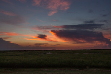 Sunset over the Ocean with puffy Clouds