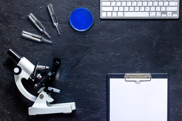 Laboratory tests. Work table witn microscope, Petri dish and ampoule on stone background top view mockup copyspace