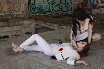 Two business women are fighting at swords. One of them is defeated