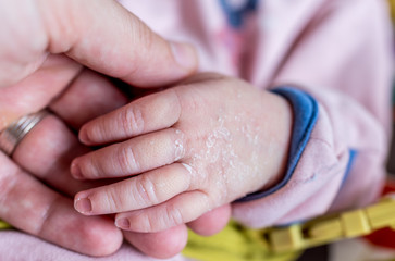 Fathers hand holding newborn