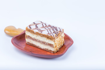Mille-feuille Napoleon french pastry on a cashew fruit format massaranduba wood dish isolated on white background