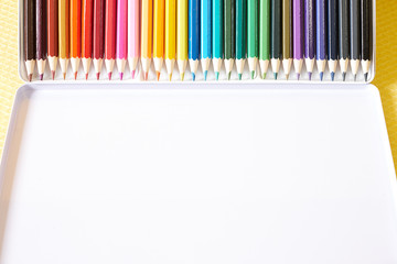 Colorful pencils on yellow background