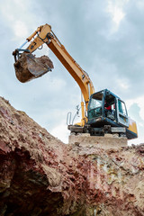 Excavator digging a trench. Work on the construction site.