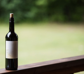 Wine background with a black wine bottle with label. Selective focus.