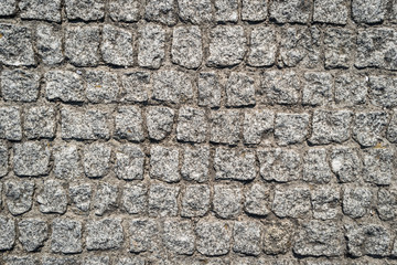 Stone pavement texture. Granite cobblestoned pavement background.