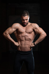 Obraz na płótnie Canvas Muscular Model Flexing Back Muscles Pose