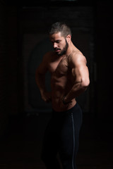 Fototapeta na wymiar Muscular Model Flexing Back Muscles Pose