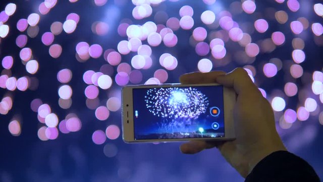 Close uf of the phone recording a video of fireworks.