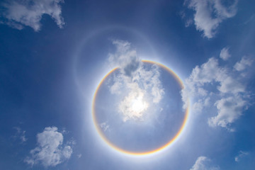 Obraz na płótnie Canvas sun corona rainbow clouds and blue sky background , Circumscribed halo