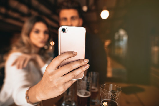 Couple sitting in the bar and taking a selfie