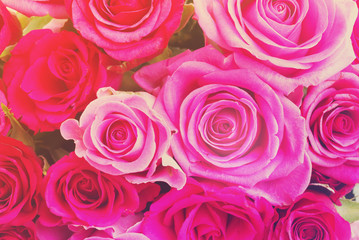 round bouquet of pink and magenta roses close up background, retro toned