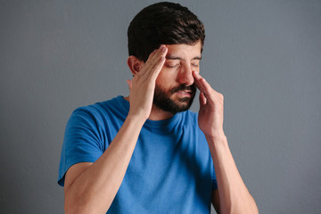 Sinus pain, sinus pressure, sinusitis. Sad man holding his nose because sinus pain