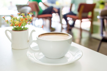 Cup of coffee on a table with flowers