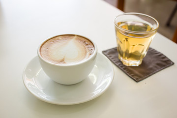 Hot Cappuccino Coffee cup on the wood table in shop