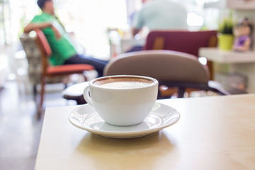 Hot Cappuccino Coffee cup on the wood table in shop