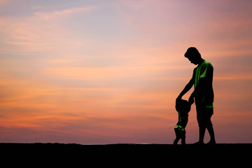 silhouette dad hold his daughter's hand to walk on red sky background