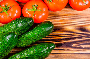 Ripe tomatoes, radish and cucumbers on wooden table. Top view