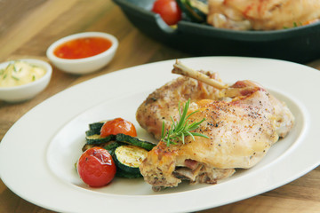 Grilled rabbit and vegetables - tomatoes and zucchini. Close up view.