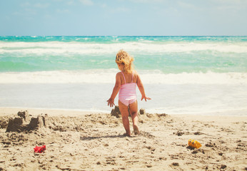 little girl play with sand on beach