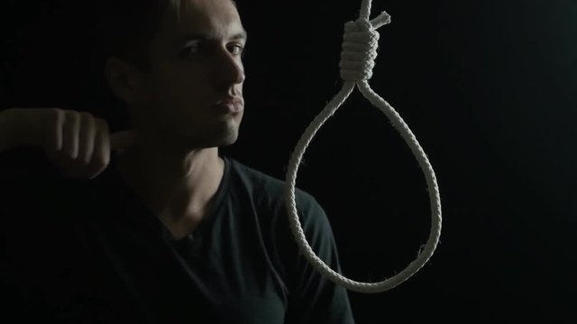 Suicide concept. Man on the background of the loop for the neck.