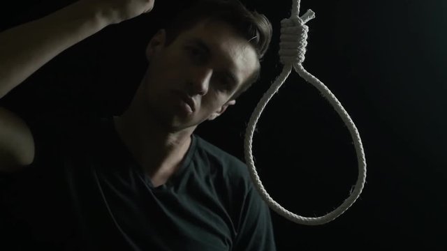 Suicide concept. Man on the background of the loop for the neck.
