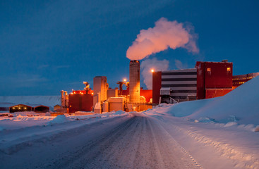 A manufacturing factory with smoking stalk. Iron ore mining industry beyond the polar circle,...