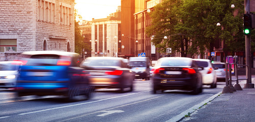 Auto& 39 s rijden op de stedelijke weg in de schemering in de zomer. Vervoer in de stad