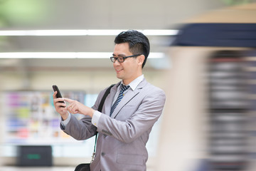 Businessman using smartphone at subway. © WONG SZE FEI