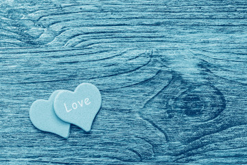 A wooden surface of blue denim color with a heart and a word of love.