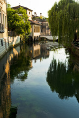 The old church of Santa Maria della Pietà is reflected on the Livenza river in Sacile. Italy