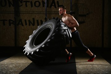 Obraz na płótnie Canvas Man pulling tire with knee