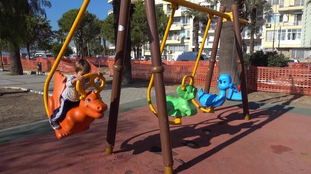 4K Child on animal shaped swing