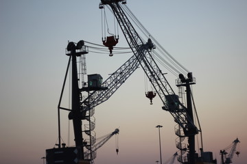 Fototapeta premium Construction cranes against the background of a summer gradient sky. perfect gradient sky.