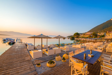 Fototapeta na wymiar Beautiful terrace and beach illuminated by sunrise in Nikiana village, Lefkada, Greece