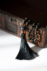 Beautiful handmade mala gems beads with tassel for mantras and meditation. Casket background.