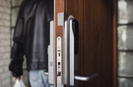 Close-up of modern lock on door with senior man in background