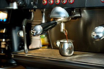 Fresh coffee pouring into cup. Espresso machine do some hot caffeine drinking