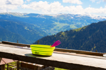 Green plate with a red fork on the veranda of the shelter