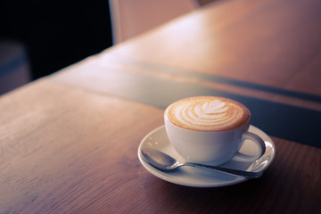 cup of coffee latte art on the wood desk coffee shop cafe