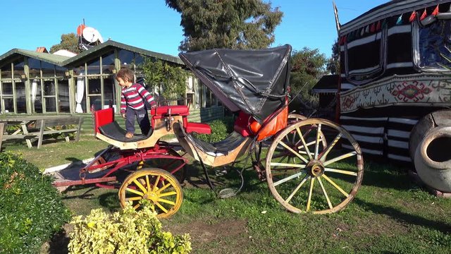 4K Child explores an old original carriage near authentic Byzantine tent