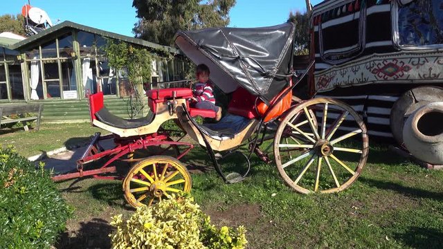 4K Old original carriage without horses and a child on it
